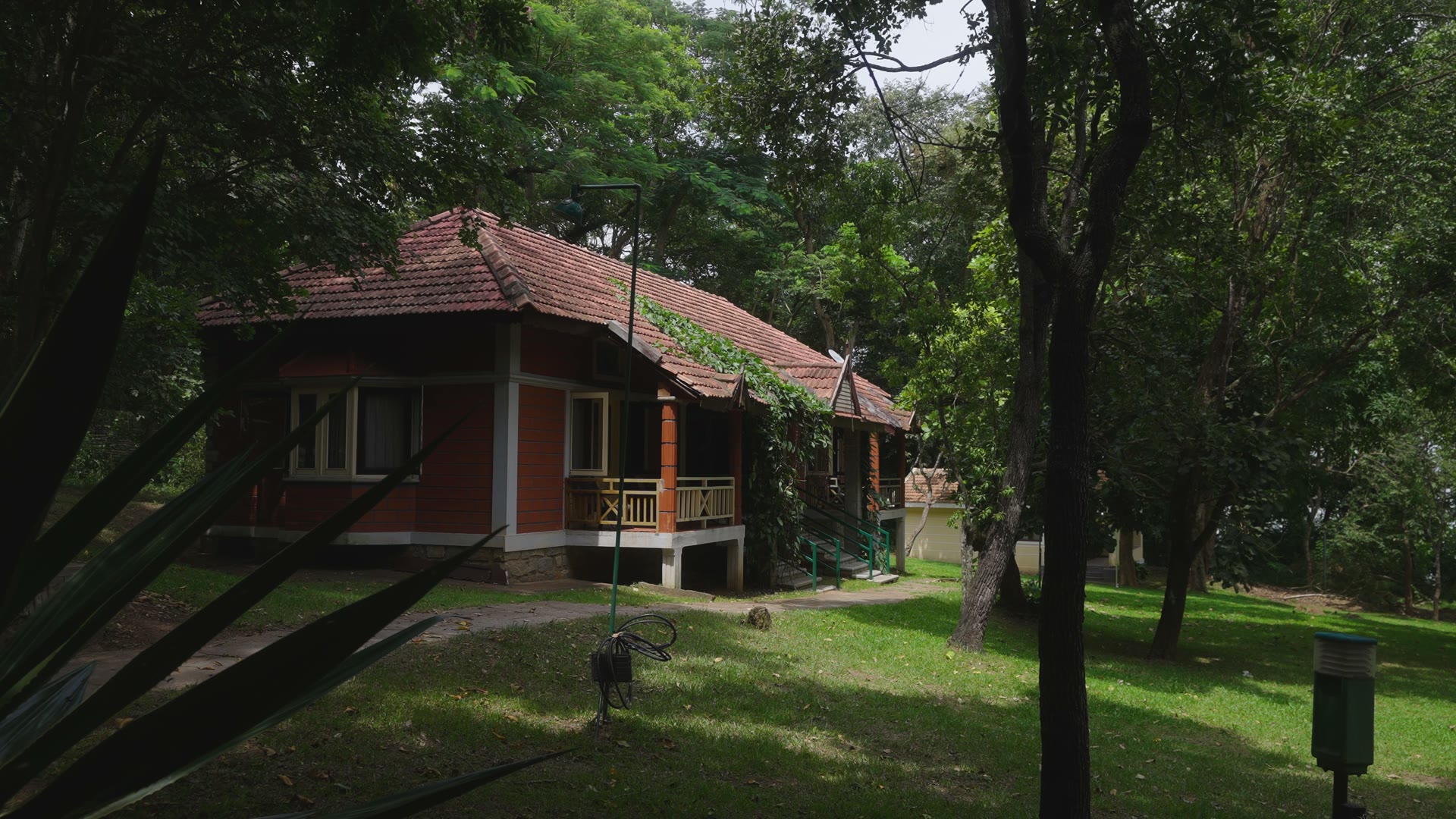 Traditional architectural resort verandah and lush tropical lawn.