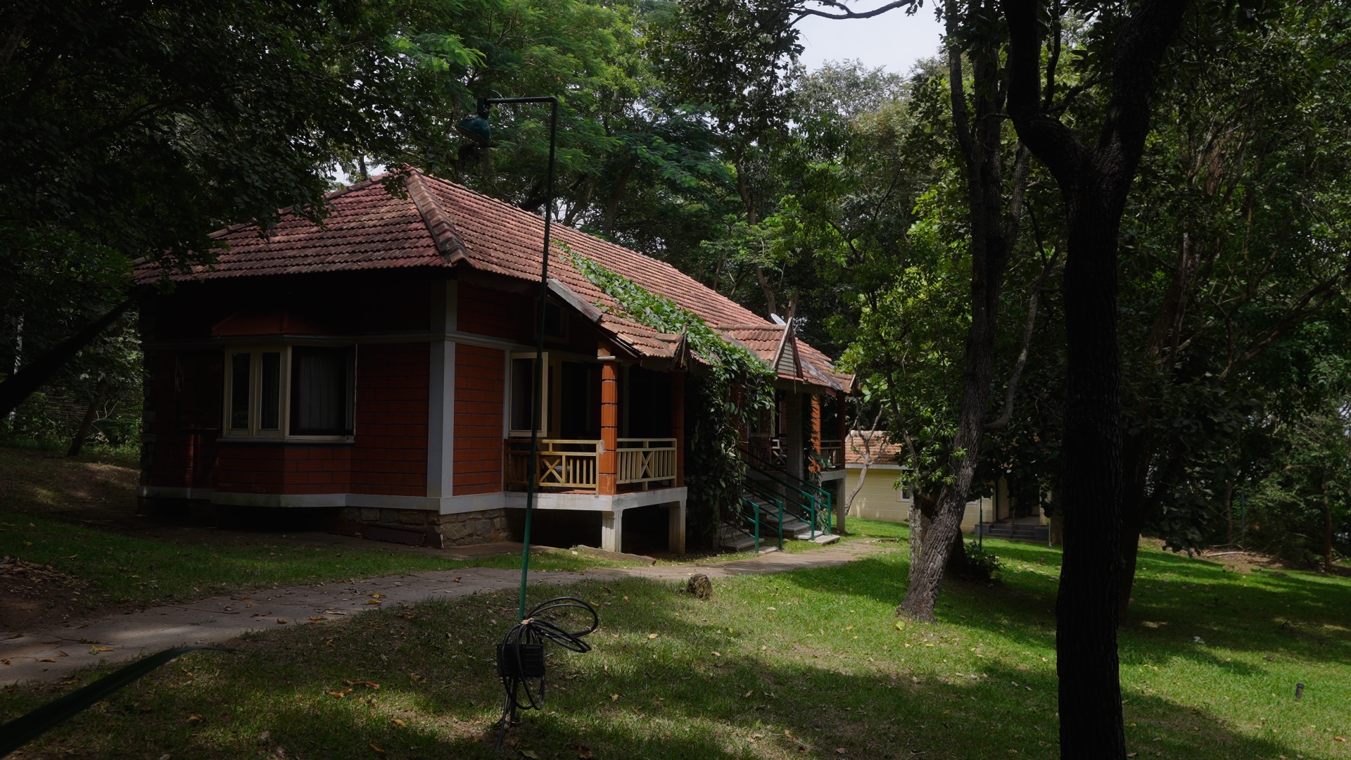 A red-roofed cottage under a green canopy at Jungle Lodges and Resorts.