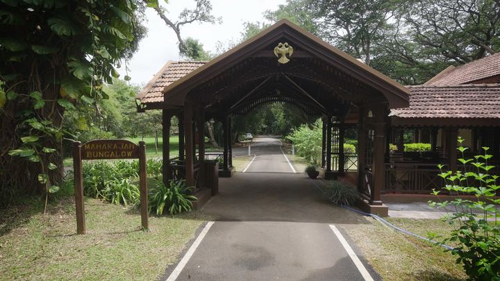 Closer view of the carved timber gatehouse and its signboard.