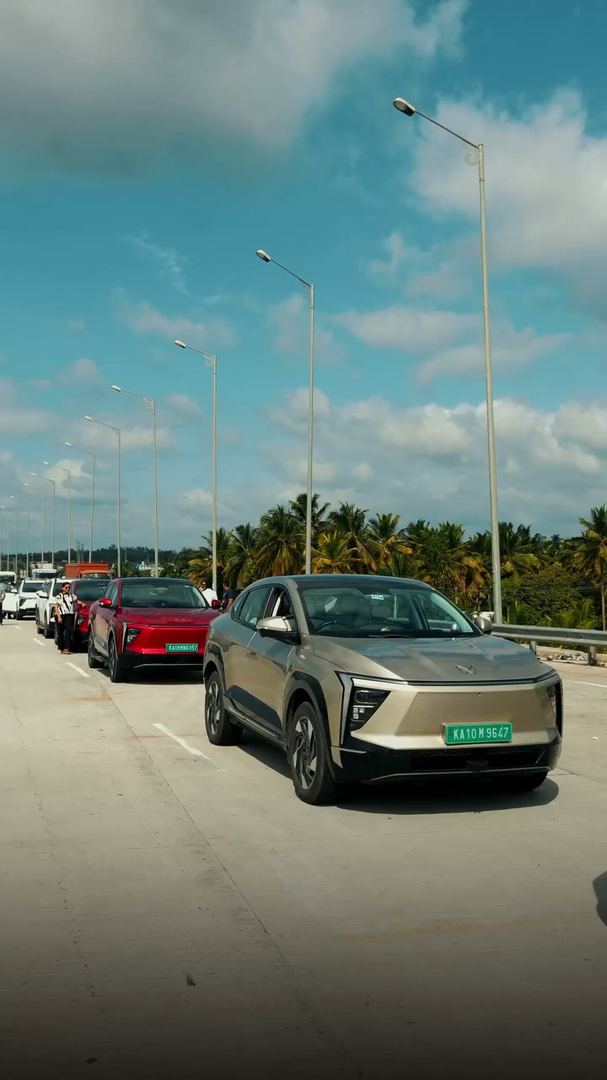 Electric SUVs parked in a row under a wide blue sky.