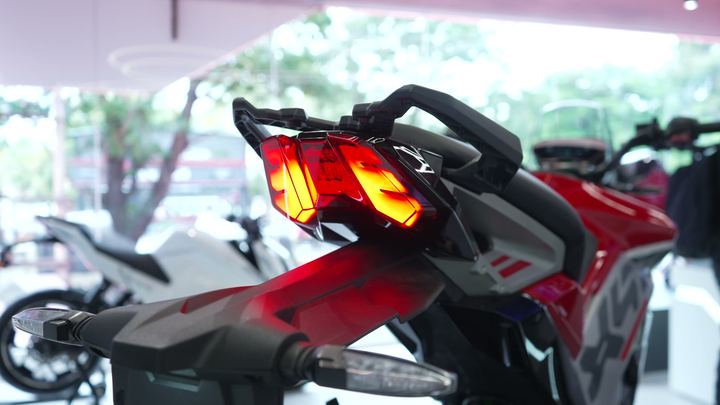 Glowing red tail light of an Ultraviolette motorcycle.