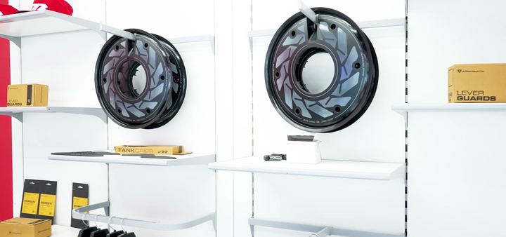 Spare wheels and accessories displayed on white showroom shelves.