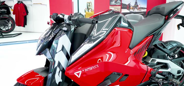 Red and white side fairing of an Ultraviolette motorcycle.