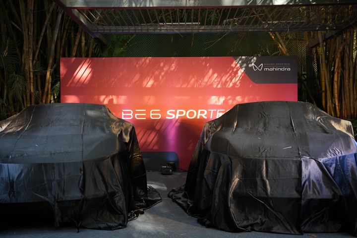 Closer view of the two covered cars before the BE 6 reveal.