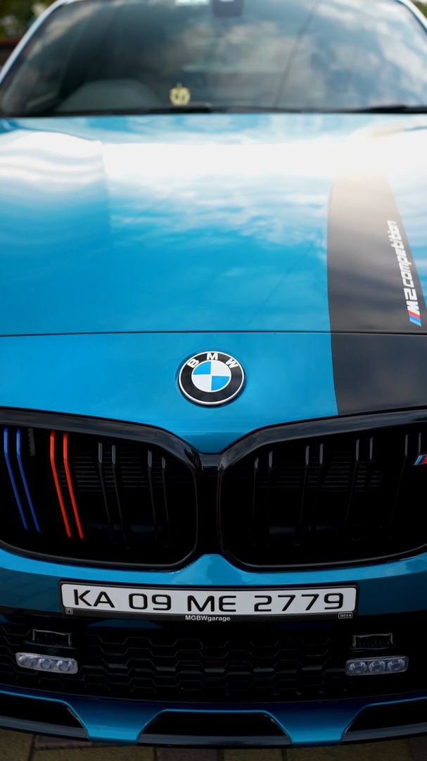 Front grille and bonnet of a teal BMW M2.