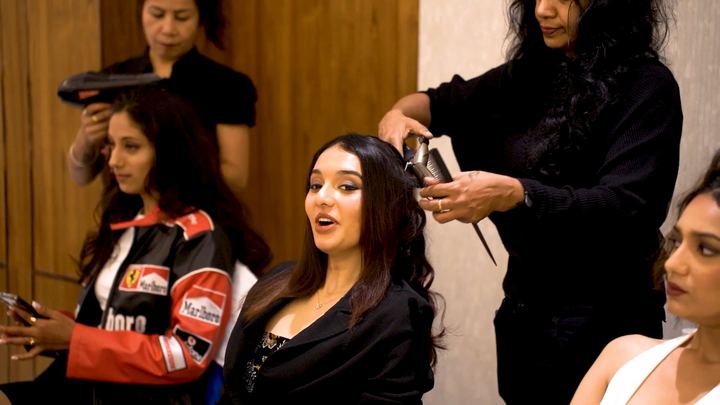 Stylists curl and style contestants hair backstage.