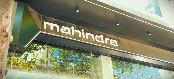Mahindra showroom sign lit against a glass facade.