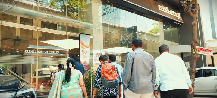 Families walk into the Mahindra showroom.
