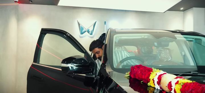Garlanded SUV with its door open inside the showroom.