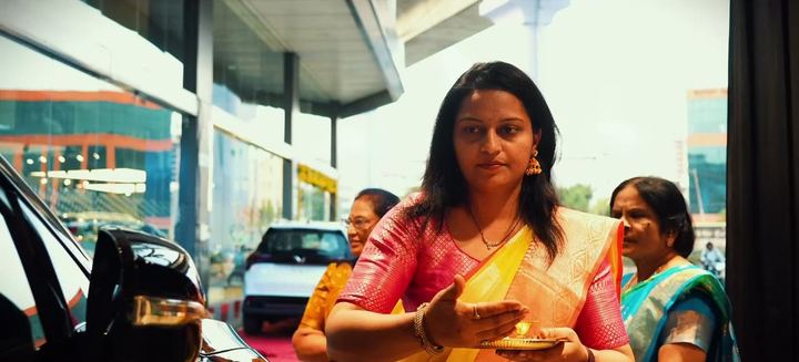 Woman in a silk sari performs a small blessing at the car.