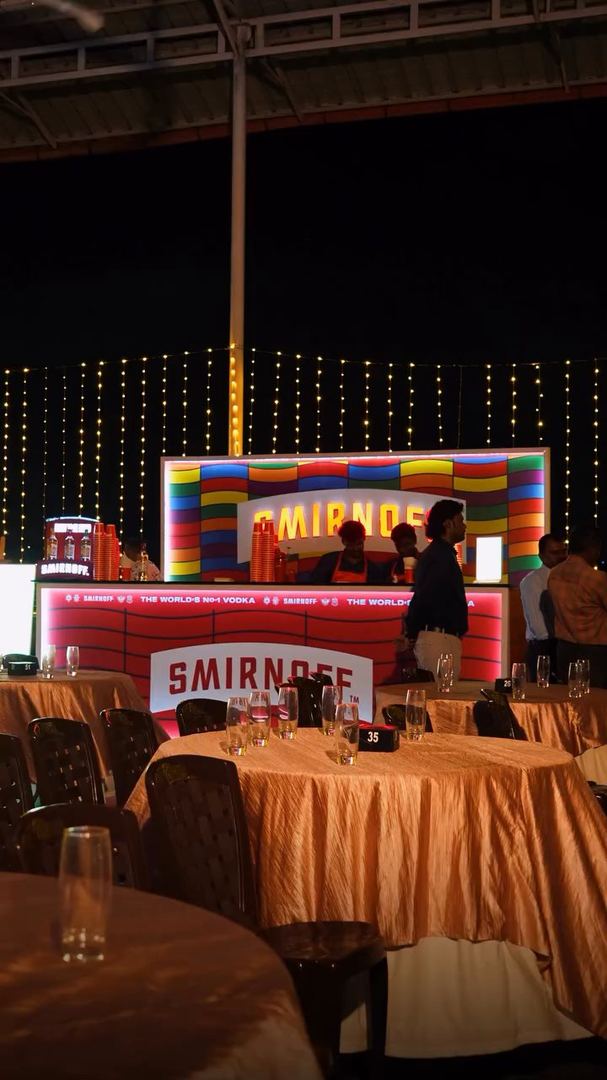 Smirnoff bar under fairy lights, tables set for guests.