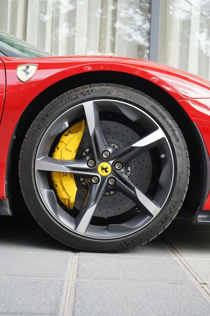 Ferrari wheel with a yellow brake caliper, shot up close.