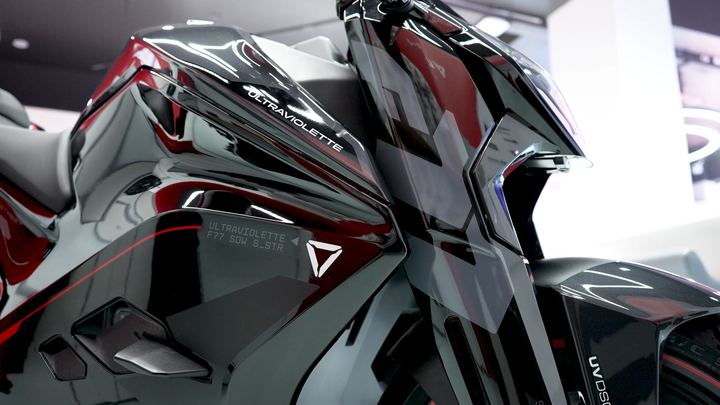 Close-up of the angular black and red fairing on an Ultraviolette motorcycle.
