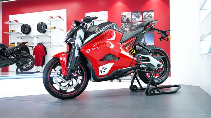 Red Ultraviolette LSR 77 motorcycle on a paddock stand in the showroom.
