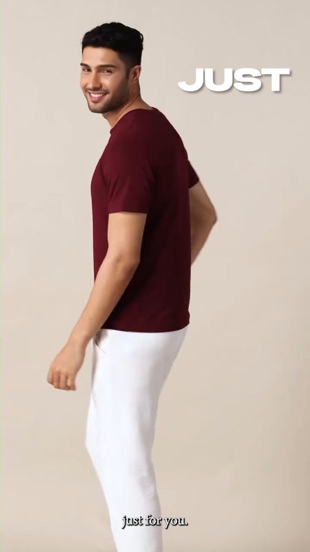 Model in a maroon T-shirt smiles over his shoulder beside the word Just.